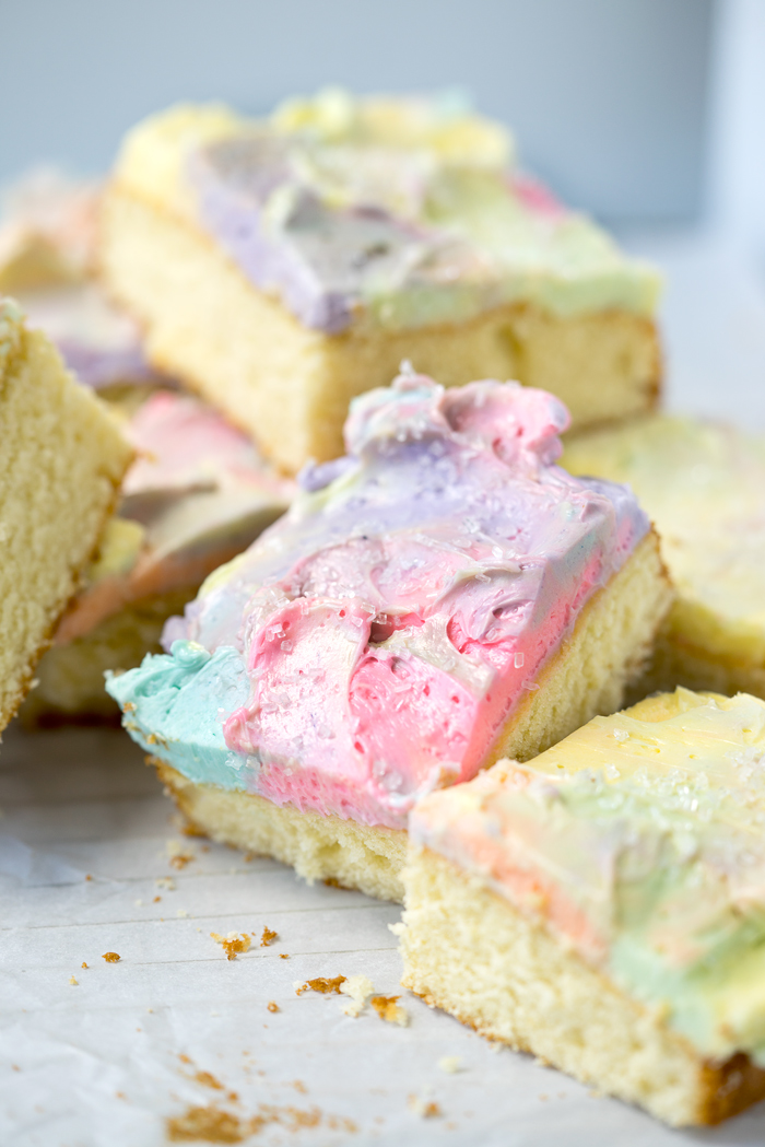 Rainbow Frosted Sheet Cake. I'm in love with this simple, moist yellow cake enrobed in a blanket of rainbow swirled swiss meringue buttercream. | thesugarcoatedcottage.com