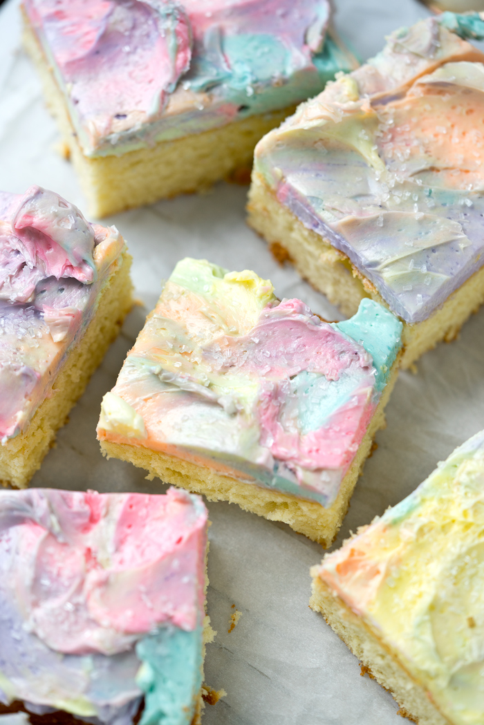 Rainbow Frosted Sheet Cake. I'm in love with this simple, moist yellow cake enrobed in a blanket of rainbow swirled swiss meringue buttercream. | thesugarcoatedcottage.com