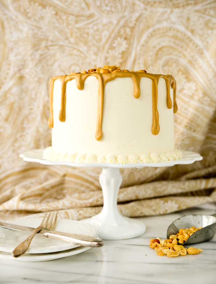 Dreamy White Chocolate Peanut Butter Cake Recipe. I'm in love with layers of white chocolate cake, white chocolate buttercream and creamy peanut butter ganache!! | thesugarcoatedcottage.com