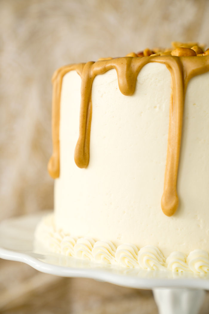 Dreamy White Chocolate Peanut Butter Cake Recipe. I'm in love with layers of white chocolate cake, white chocolate buttercream and creamy peanut butter ganache!! | thesugarcoatedcottage.com