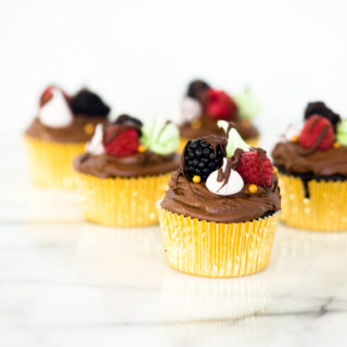 Chocolatey Fudge Cupcake Recipe. Moist, fluffy, pillowy cupcakes in a swirl of fudge chocolate frosting. Decorated in fresh berries and crisp meringues. | thesugarcoatedcottage.com