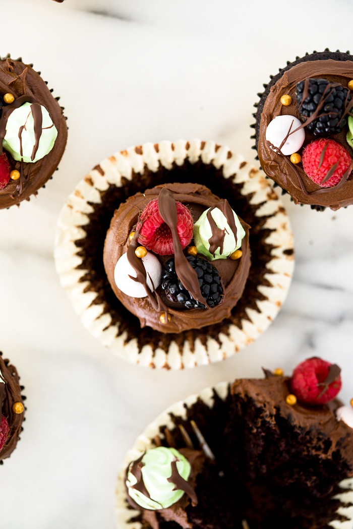 Chocolatey Fudge Cupcake Recipe. Moist, fluffy, pillowy cupcakes in a swirl of fudge chocolate frosting. Decorated in fresh berries and crisp meringues. | thesugarcoatedcottage.com