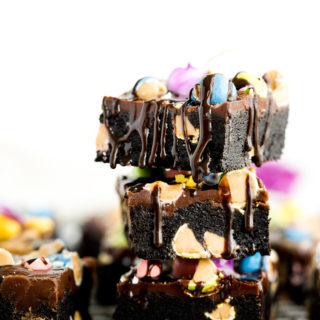 Reese's Pieces Double Fudge Brownie Recipe. My childhood favorite candy, Reese's Pieces, folded into deep dark fudge brownies and then sprinkled on top of fudgy frosting. By far the best fudgy brownie recipe!! | thesugarcoatedcottage.com #brownies #recipe #reeses pieces #frosting
