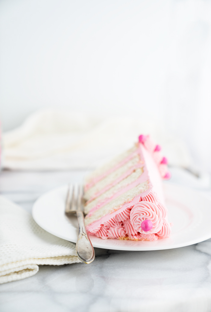 Its a Girl Baby Shower Cake Recipe! White Chocolate Cake coated in a delicate pink white chocolate swiss meringue buttercream. Pink cake, frosting, buttercream, baby shower, cake. | thesugarcoatedcottage.com