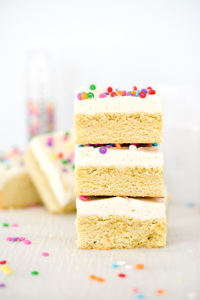 Vanilla Bean Buttercream Frosted Sugar Cookie Bar Recipe. Smooth, creamy vanilla bean flecked swiss meringue buttercream on top of sweet, buttery, sugar cookie bars. | thesugarcoatedcottage.com #recipe #cookies #baking #sugarcookie #buttercream