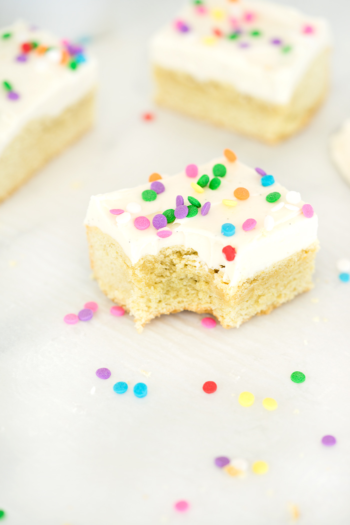 Vanilla Bean Buttercream Frosted Sugar Cookie Bar Recipe. Smooth, creamy vanilla bean flecked swiss meringue buttercream on top of sweet, buttery, sugar cookie bars. | thesugarcoatedcottage.com #recipe #cookies #baking #sugarcookie #buttercream