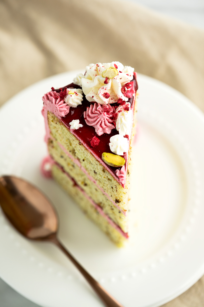 Pistachio Raspberry Cake Recipe. Deliciously nutty layers of cake enrobed in a beautiful raspberry swiss meringue buttercream. Looking for a unique cake for that special occasion then this is it! | thesugarcoatedcottage.com #cake #recipe #pistachiocake #buttercream #raspberry