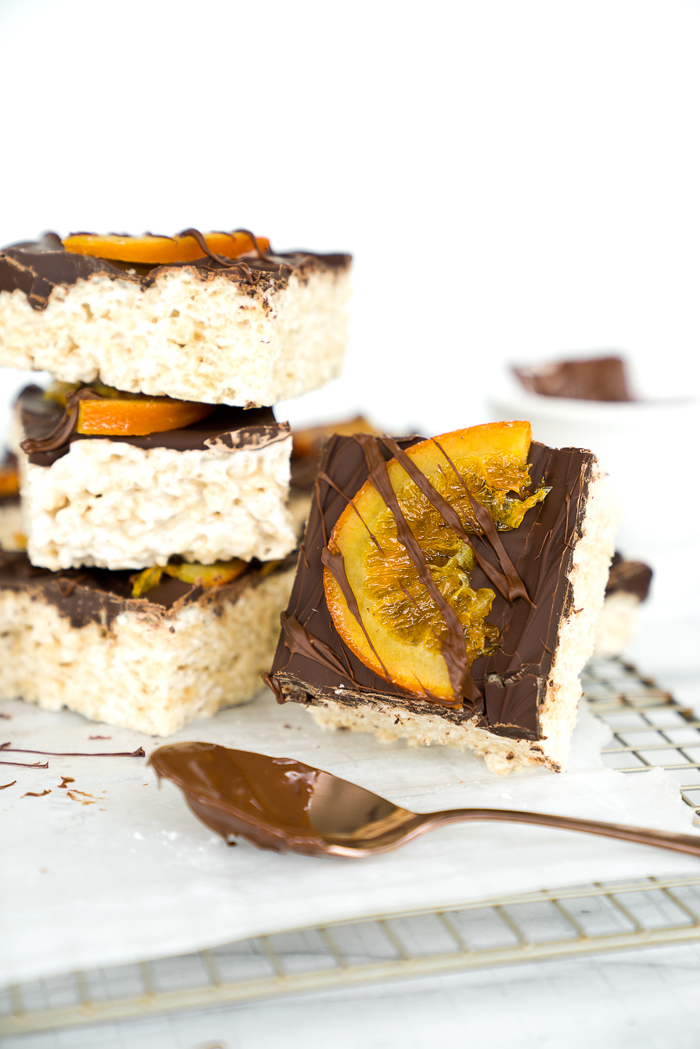 Candied Orange Chocolate Rice Krispies Treats Recipe. Gooey, marshmallowy Rice Krispies Treats smothered in a coating of chocolate and adorned by slices of candied oranges. There's no other way to eat a childhood classic. | thesugarcoatedcottage.com | #ricekrispiestreats #barcookies #recipe #dessert