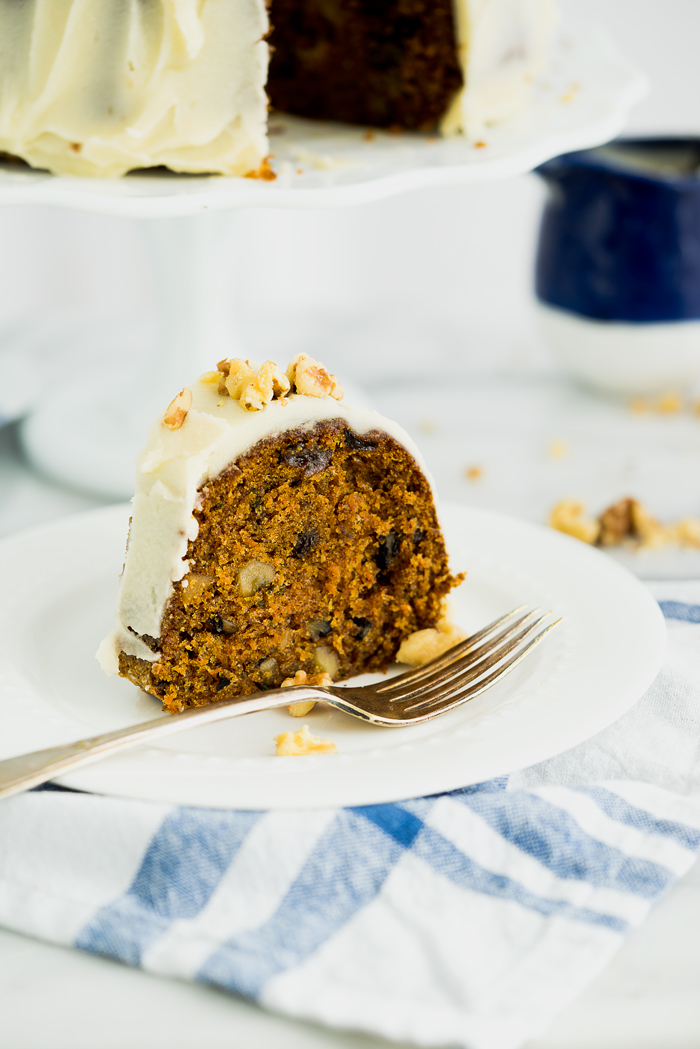 Rum Raisin Carrot Bundt Cake Recipe. Moist, dense, spiced carrot cake with spiced rum soaked raisins and buttery rum icing. The best carrot cake! | thesugarcoatedcottage.com #cake #carrotcake #bundtcake