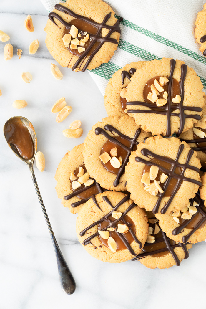 Caramel Peanut Butter Cookies. Crispy edged soft peanut butter cookies with a pool of caramel and chocolate drizzle. Cookies, peanut butter, caramel | thesugarcoatedcottage.com