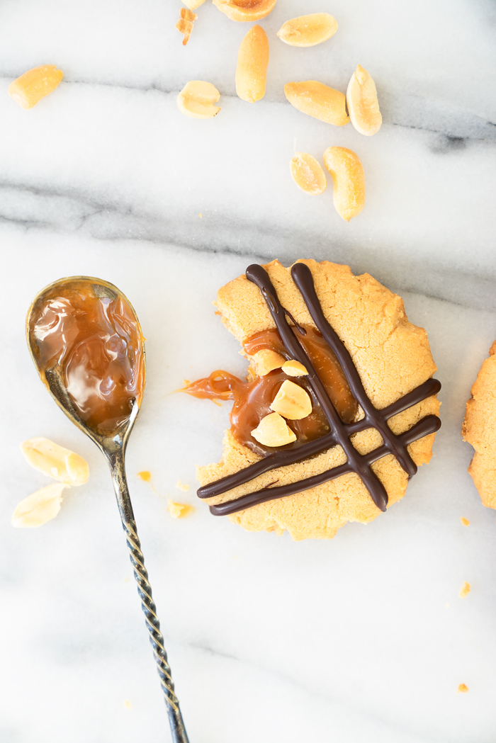 Caramel Peanut Butter Cookies. Crispy edged soft peanut butter cookies with a pool of caramel and chocolate drizzle. Cookies, peanut butter, caramel | thesugarcoatedcottage.com