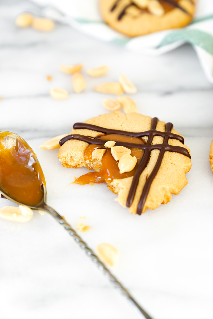 Caramel Peanut Butter Cookies. Crispy edged soft peanut butter cookies with a pool of caramel and chocolate drizzle. Cookies, peanut butter, caramel | thesugarcoatedcottage.com