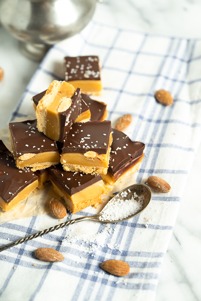 Roasted Almond Millionaire Shortbread - shortbread cookie base, generous caramel layer, roasted almonds, blanket of chocolate and a sprinkling of sea salt. #twix #millionaireshortbread #shortbread #cookie | thesugarcoatedcottage.com