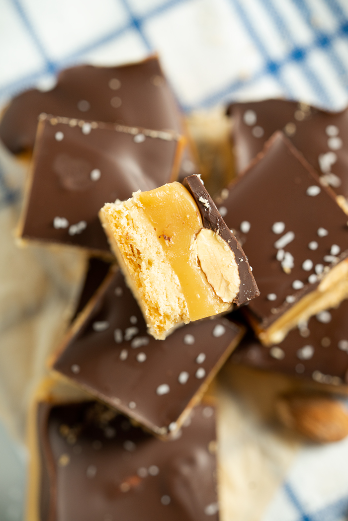 Roasted Almond Millionaire Shortbread - shortbread cookie base, generous caramel layer, roasted almonds, blanket of chocolate and a sprinkling of sea salt. #twix #millionaireshortbread #shortbread #cookie | thesugarcoatedcottage.com