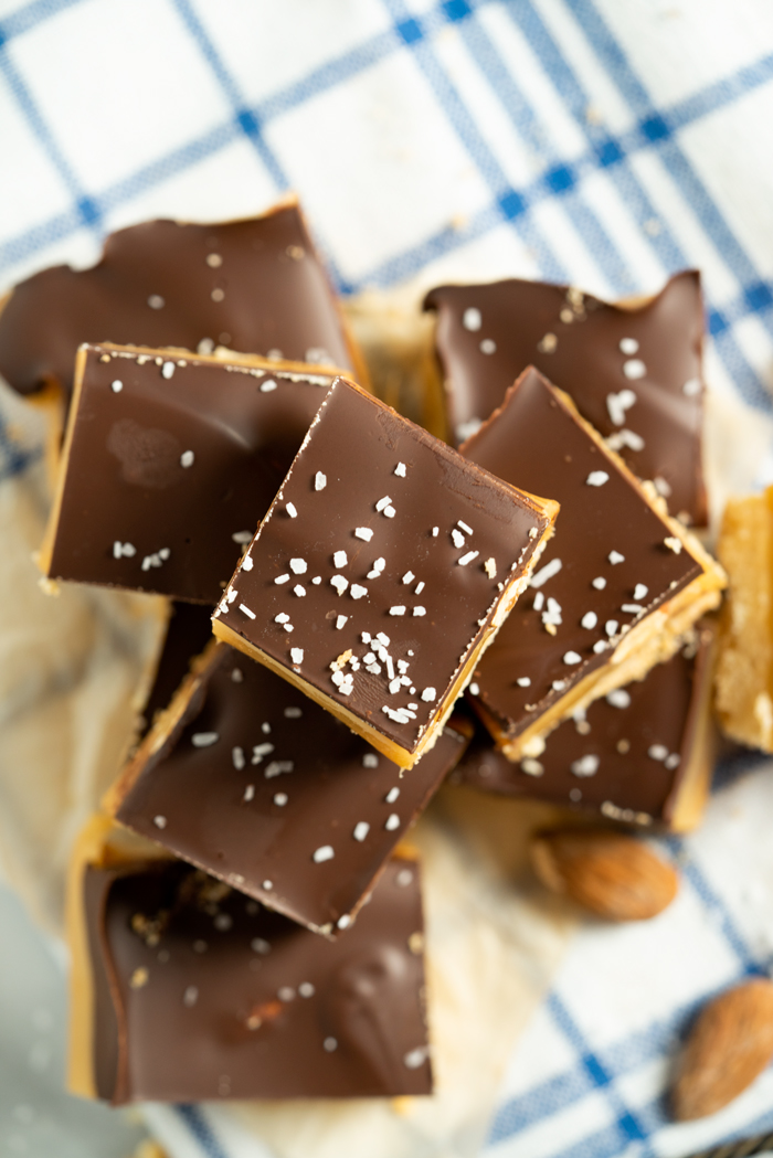 Roasted Almond Millionaire Shortbread - shortbread cookie base, generous caramel layer, roasted almonds, blanket of chocolate and a sprinkling of sea salt. #twix #millionaireshortbread #shortbread #cookie | thesugarcoatedcottage.com