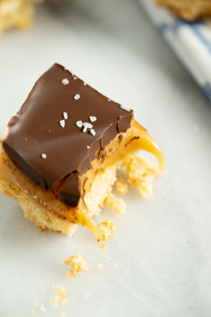 Roasted Almond Millionaire Shortbread - shortbread cookie base, generous caramel layer, roasted almonds, blanket of chocolate and a sprinkling of sea salt. #twix #millionaireshortbread #shortbread #cookie | thesugarcoatedcottage.com