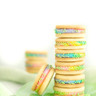 Buttercream Sandwich Cookie Recipe. Crispy sugar cookies sandwiching sweet buttercream. | thesugarcoatedcottage.com #cookies #buttercream #sandwich #rainbow