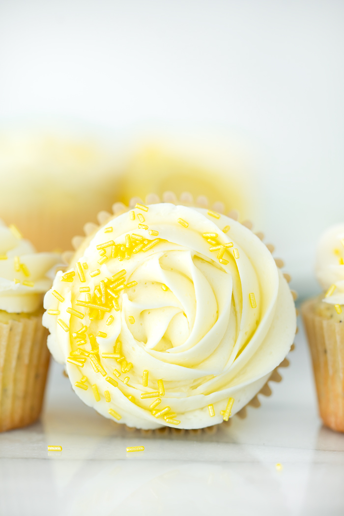 Lemon Poppy Seed Cupcakes. Bright lemony cupcakes speckled with poppy seeds, swirled with lemon buttercream. | thesugarcoatedcottage #cupcake #cake #lemon