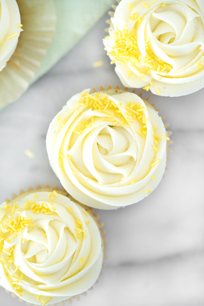 Lemon Poppy Seed Cupcakes. Bright lemony cupcakes speckled with poppy seeds, swirled with lemon buttercream. | thesugarcoatedcottage #cupcake #cake #lemon