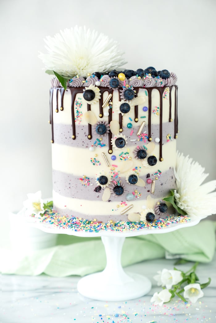 Buttermilk Blueberry Almond Cake Recipe. Blueberry studded cake, hints of almond, blueberry filling all coated in blueberry buttercream! #cake #blueberries