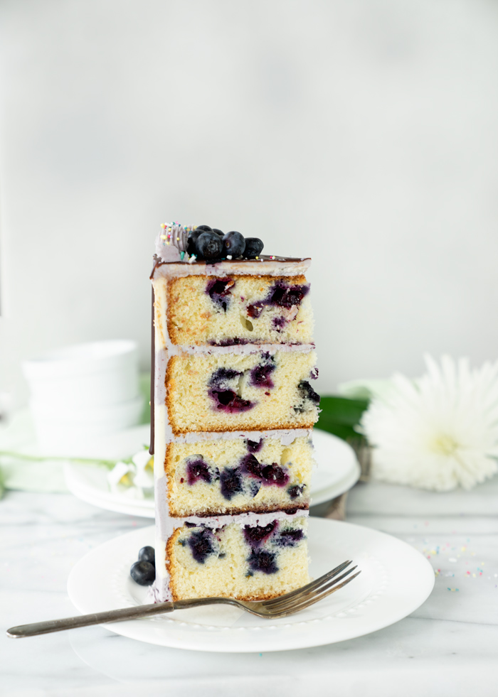 Buttermilk Blueberry Almond Cake Recipe. Blueberry studded cake, hints of almond, blueberry filling all coated in blueberry buttercream! #cake #blueberries 