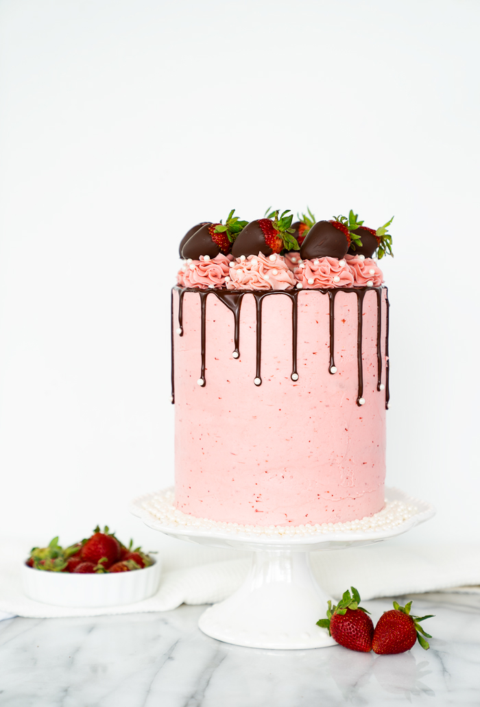 Strawberry Cake enrobed in strawberry buttercream! The best cake for any occasions. #cake #strawberries #recipe #cakedecorating
