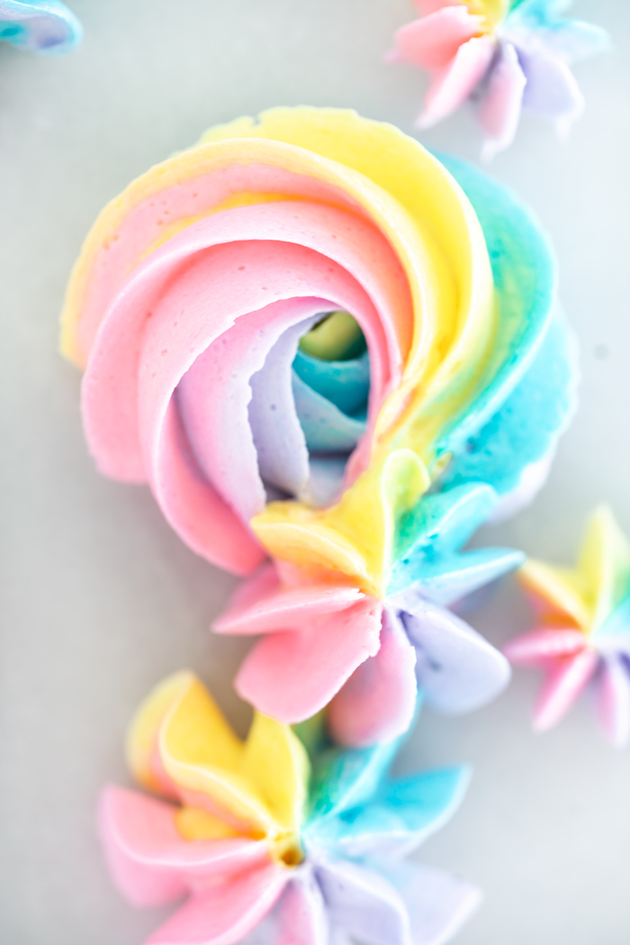 Rainbow buttercream tutorial complete with photos. Now you can make pretty rainbow rosettes and decorations. #cake decorating #cake #buttercreamtutorial