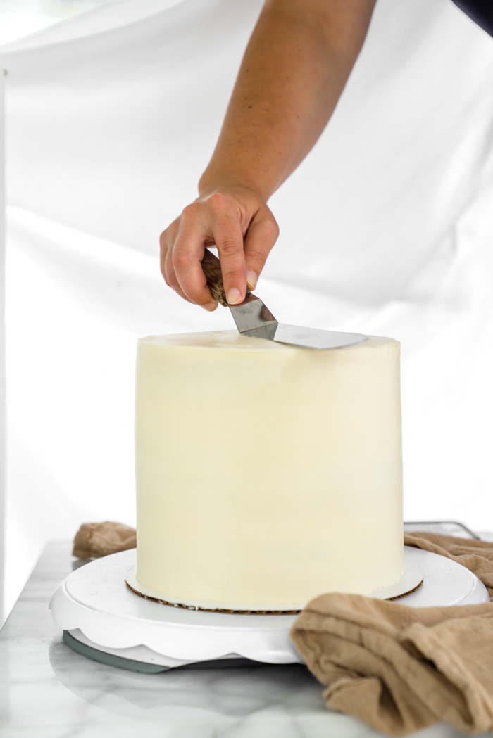 Smooth cake out, dip spatula in warm water/wipe, gently go around cake to smooth out the buttercream appearance.