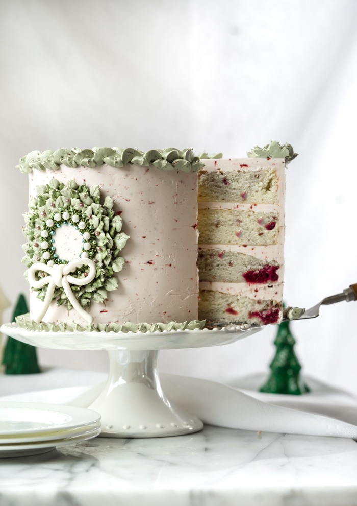 Raspberry Almond Cake. Sweet tart raspberries folded into an almond flavored cake and coated in raspberry almond buttercream. #cake #cakedecorating #cupcake