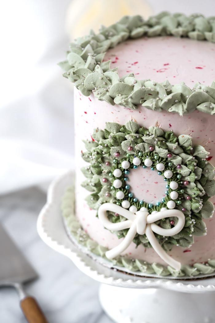 Raspberry Almond Cake. Sweet tart raspberries folded into an almond flavored cake and coated in raspberry almond buttercream. #cake #cakedecorating #cupcake