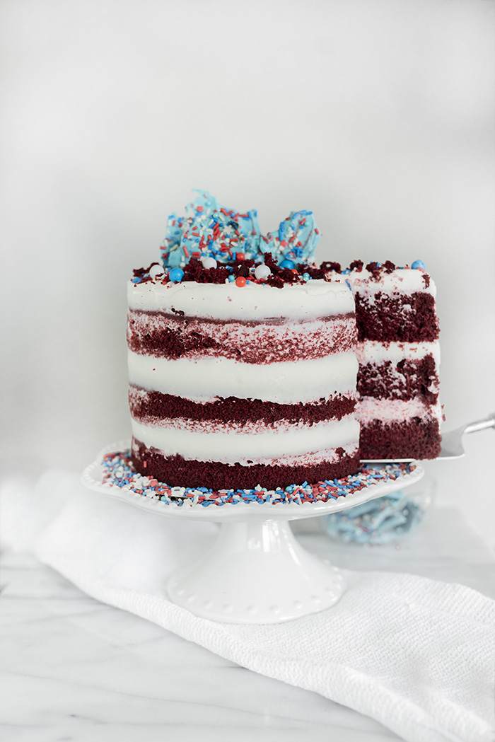 4th of July Red Velvet Cheesecake Cake. Moist, tender crumb red velvet cake with layers of whipped cheesecake filling. #4thofjuly #redvelvet #cheesecake #cake #redvelvetcheesecake