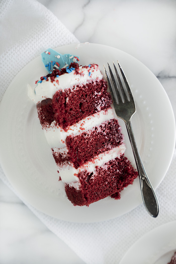 4th of July Red Velvet Cheesecake Cake. Moist, tender crumb red velvet cake with layers of whipped cheesecake filling. #4thofjuly #redvelvet #cheesecake #cake #redvelvetcheesecake